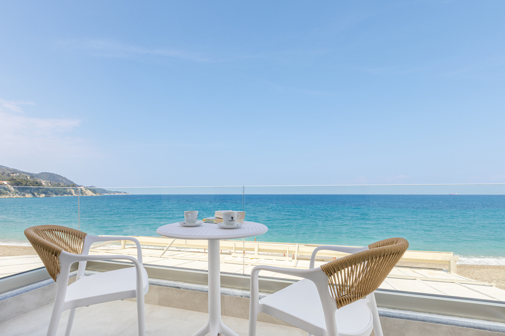 Sea view balcony with table and chairs overlooking the beach at Azzure Studio in Kokkari Samos