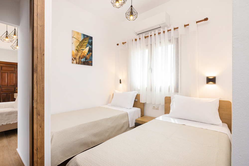 Twin bedroom with two single beds and modern decor at Azzure Studio in Kokkari Samos