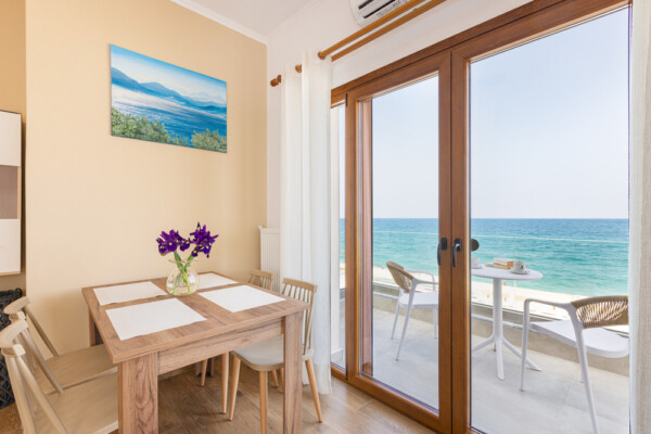 Dining area with table and balcony overlooking the sea at Azzure Studio in Kokkari Samos