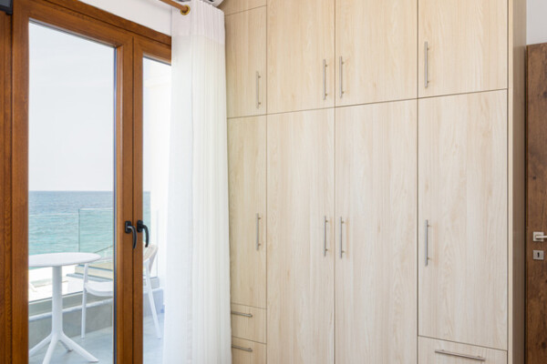 Modern bedroom with large wardrobe and sea view balcony at Azzure Studio in Kokkari Samos
