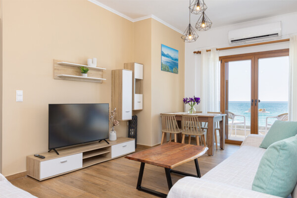 Modern living room with TV dining area and sea view balcony at Azzure Studio in Kokkari Samos