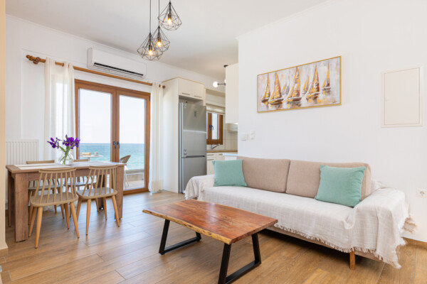 Open plan living and dining area with sofa and sea view balcony at Azzure Studio in Kokkari Samos